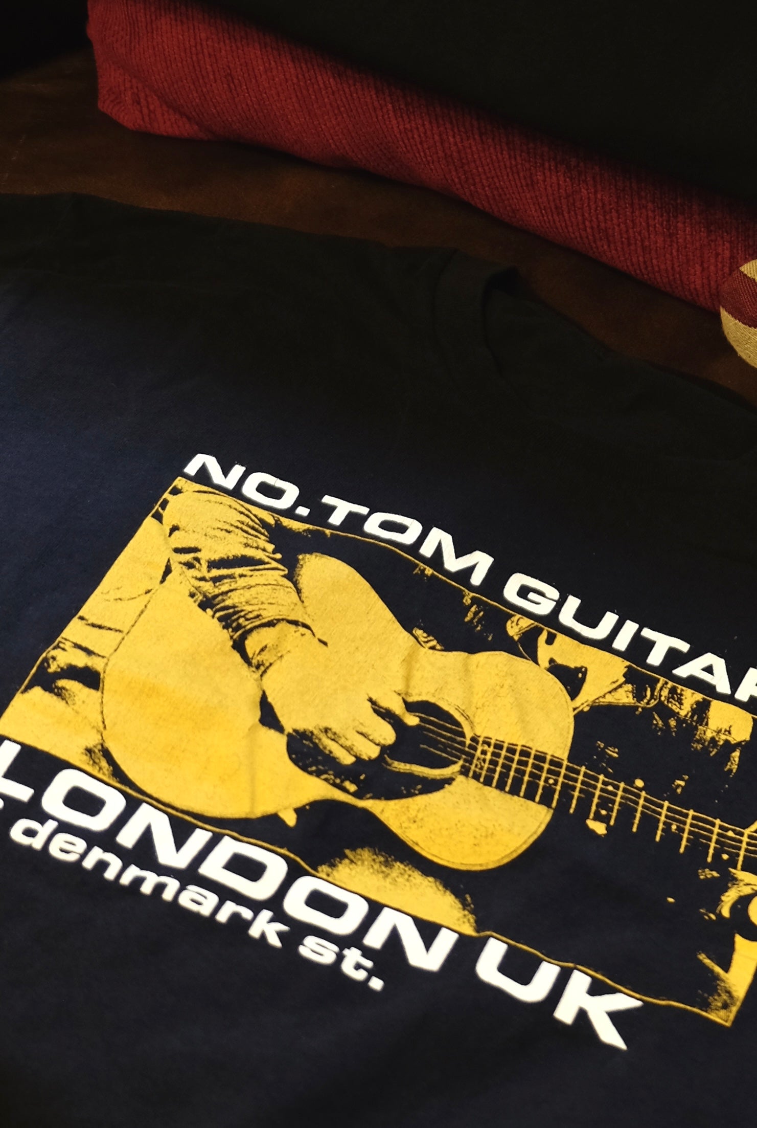 closeup of a Limited Edition No.Tom T Shirt in black with yellow logo