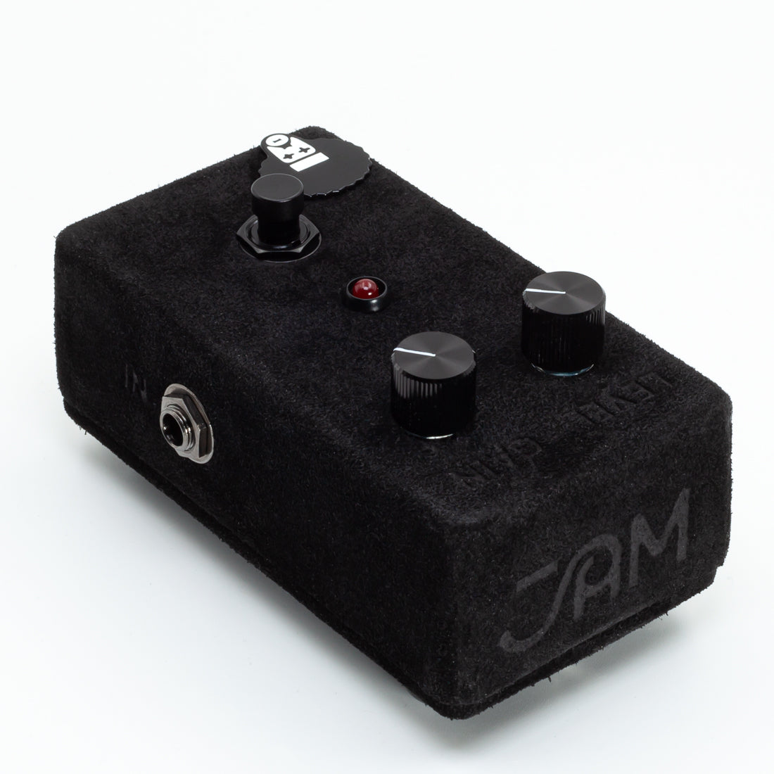 Black guitar effects pedal with knobs on a white background