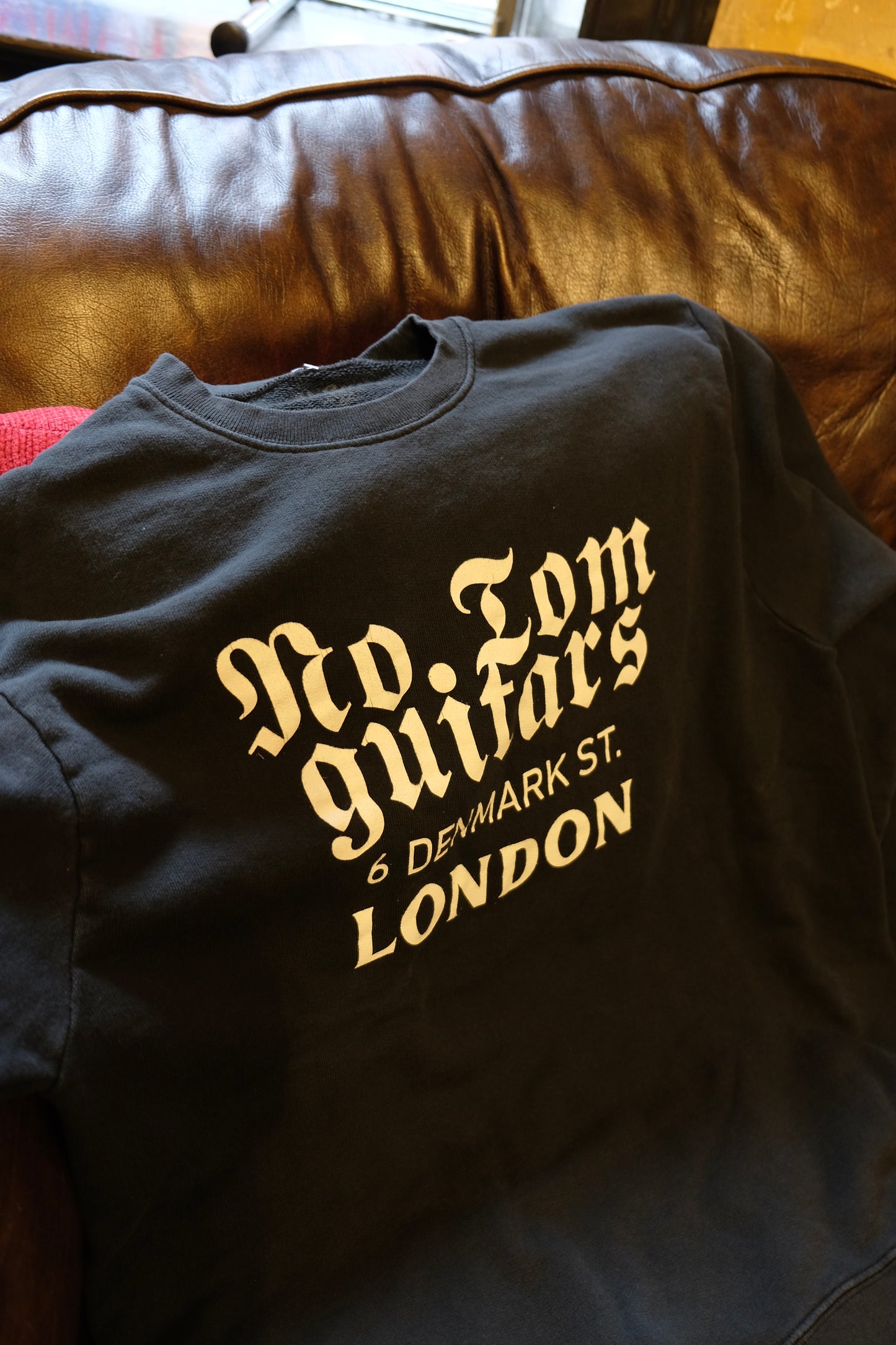 Limited Edition No.Tom Sweatshirt - gothic logo laying on the shop sofa closeup