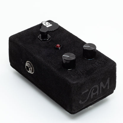 Black guitar effects pedal with knobs on a white background
