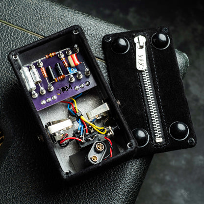 Black suede pedal enclosure with electronic components in the back