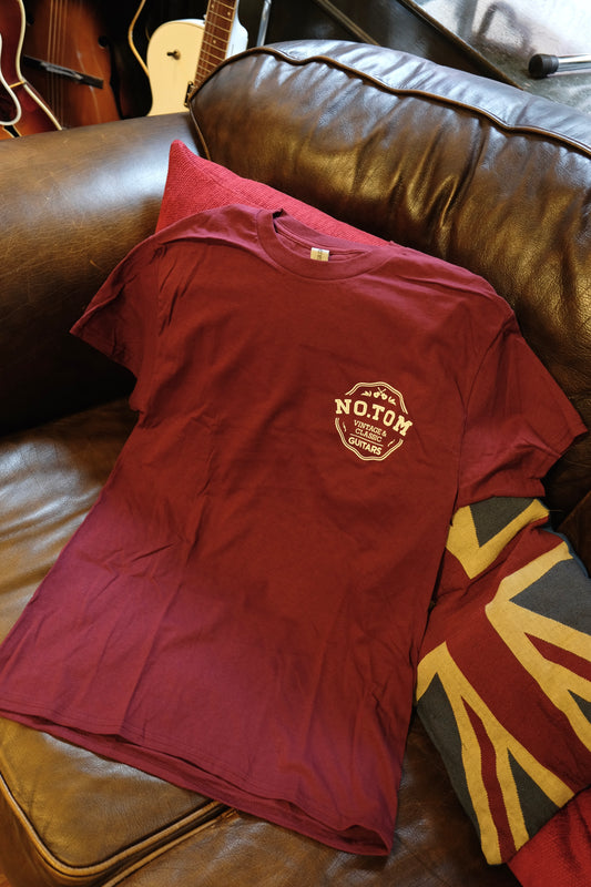 Red notom guitars t-shirt on brown leather sofa